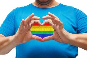 manos masculinas formando un corazón con una bandera lgbt dentro. superficie áspera de la bandera del arco iris foto