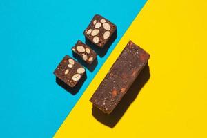 Protein date fruit candy bars fitness with nuts top view on blue yellow background with copy space and place for text photo