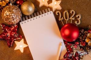 notebook with blank pages with New Year's toys, gifts and numbers 2023. Plans and dreams for the New Year, space for text photo