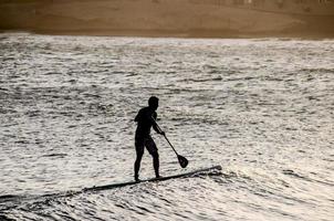 Silhouette of a man in paddle board photo