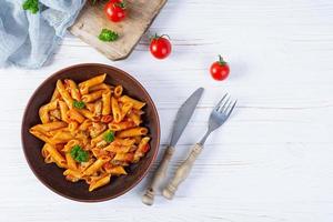 Pasta penne in marinara sauce with mussels, onion and parsley. Classic Italian pasta penne. Top view