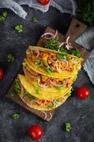 Mexican tacos with corn tortilla. Tortilla with chicken meat, corn, lettuce and onion. Top view photo