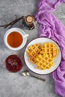 Sweet pumpkin waffles with strawberry jam. Delicious breakfast with belgian waffles. Top view photo