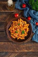 Pasta penne in marinara sauce with mussels, onion and parsley. Classic Italian pasta penne. Top view