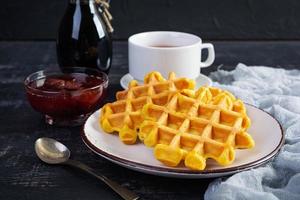 Sweet pumpkin waffles with strawberry jam. Delicious breakfast with belgian waffles photo