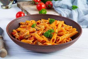 Pasta penne in marinara sauce with mussels, onion and parsley. Classic Italian pasta penne