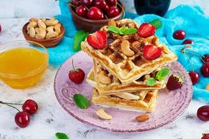 Delicious breakfast with belgian waffles. Waffels with strawberry and berry jam photo