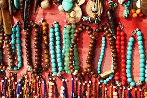 A lot of colorful bracelets and beads on a street market. photo