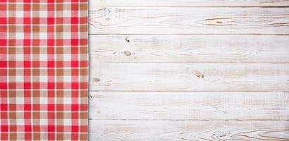 Towel or tablecloth, napkin, rough fabric texture with creased folds on wooden desk top view. photo