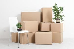 mudarse a un nuevo apartamento. mover un montón de cajas de cartón en un nuevo apartamento vacío. foto