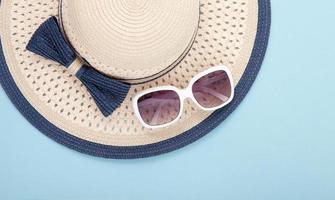 Summer hat with ribbon and sunglasses isolated on colorful background. Top view and copy space. photo