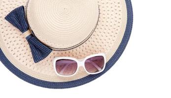 Summer hat with ribbon and sunglasses isolated on white background. Top view and copy space. photo