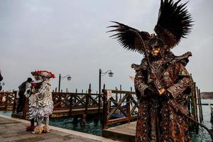 personas no identificadas con máscaras de carnaval en el carnaval de venecia en venecia, italia, alrededor de febrero de 2022 foto