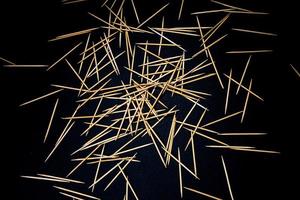 bamboo wooden toothpicks in glass jar, wine glass. in bucket. toothpicks on black background. front view toothpicks, dropped from hand, place for text, photo