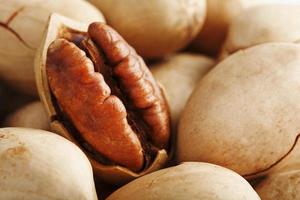 Pecan nuts close-up, macro as the background on the whole screen. Peeled, in a shell. photo