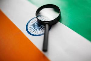 Indian flag looking through a magnifying glass. Total surveillance of the country Indian. The concept of hidden threats and control over the country photo
