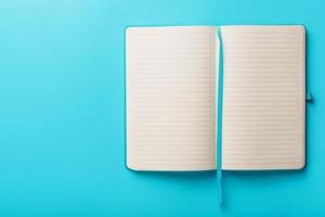 Open notebook, a book with blank and blank pages on a blue background, top view. photo