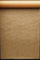 A roll of unfolded brown parchment paper, for baking food in on a dark background, top view. photo