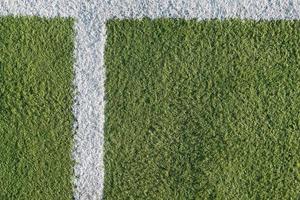 White strip in the field for football. Green texture of a football, volleyball and basketball field photo