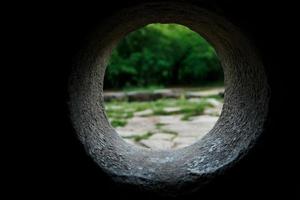 Inside view of a stone dolmen out through a hole in a mountain forest in the valley of the river Jean photo