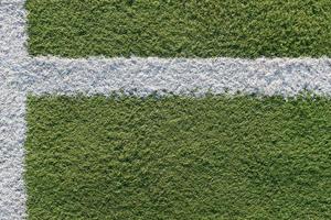 White strip in the field for football. Green texture of a football, volleyball and basketball field photo