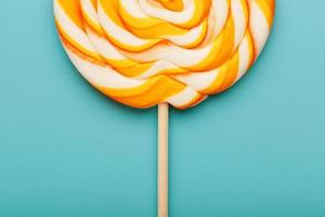 Colorful round Lollipop, on mint blue background. Minimal concept with copy space. photo