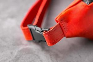 Waist bag made of red leather, banana on a gray background. Handmade photo