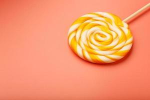 Colorful round Lollipop on pink background. Minimal concept with copy space. photo