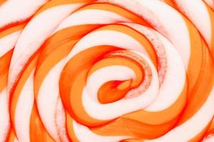 Orange round Lollipop on pink background. Minimal concept with copy space. photo