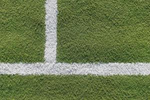 White strip in the field for football. Green texture of a football, volleyball and basketball field photo