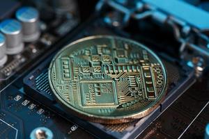 Golden Bitcoin Cryptocurrency on computer circuit board CPU. Macro shot. photo