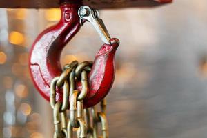 metallic chain handle with red hook in technical room. Crane cargo hook. photo