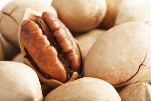 Pecan nuts close-up, macro as the background on the whole screen. Peeled, in a shell. photo