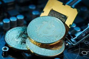 Golden Bitcoin Cryptocurrency on computer circuit board CPU. Macro shot. photo