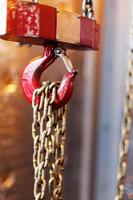 metallic chain handle with red hook in technical room. Crane cargo hook. photo