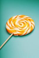 Colorful round Lollipop, on mint blue background. Minimal concept with copy space. photo