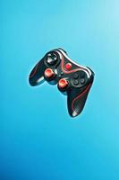 Game controller gamepad on blue background flying. Device to control and control the game. photo