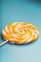 Big yellow Lollipop, in mint blue background. Minimal concept with copy space. photo