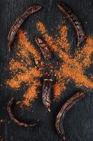 Carob carob fruit with powder on black background. Blast the Sweet powder from the pulp of the pods. photo