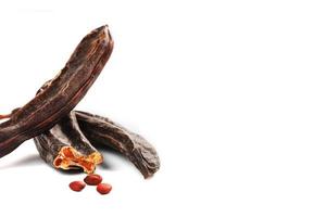 Carob carob fruit and seeds on white background. Isolate. Organic carob beans, a healthy alternative to cocoa. photo