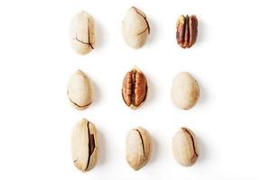 Set of peeled pecans in the center surrounded by nuts in the shell, isolated on a white background, square composition. photo