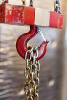 metallic chain handle with red hook in technical room. Crane cargo hook. photo