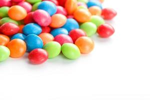 Rainbow-colored candies, multicolored close-up, texture and repetition of dragee photo