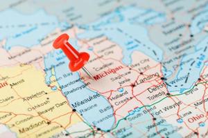 Red clerical needle on a map of USA, Michigan and the capital Lansing. Close up map of Michigan with red tack photo