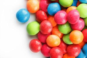 A rainbow of color from multicolored candies close-up, multi-colored glaze dragee on a white background photo