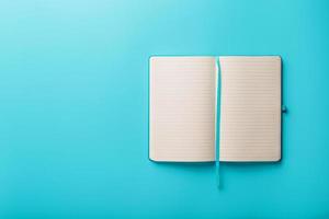 Open notebook, a book with blank and blank pages on a blue background, top view. photo