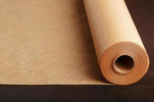 A roll of unfolded brown parchment paper, for baking food in on a dark background, top view. photo