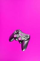 controlador de juego gamepad con botones rosas sobre fondo rosa. foto