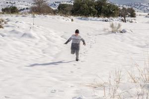 child running and enjoying the snowy landscape photo