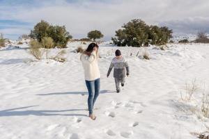 child and mother having fun in snowy landscape photo